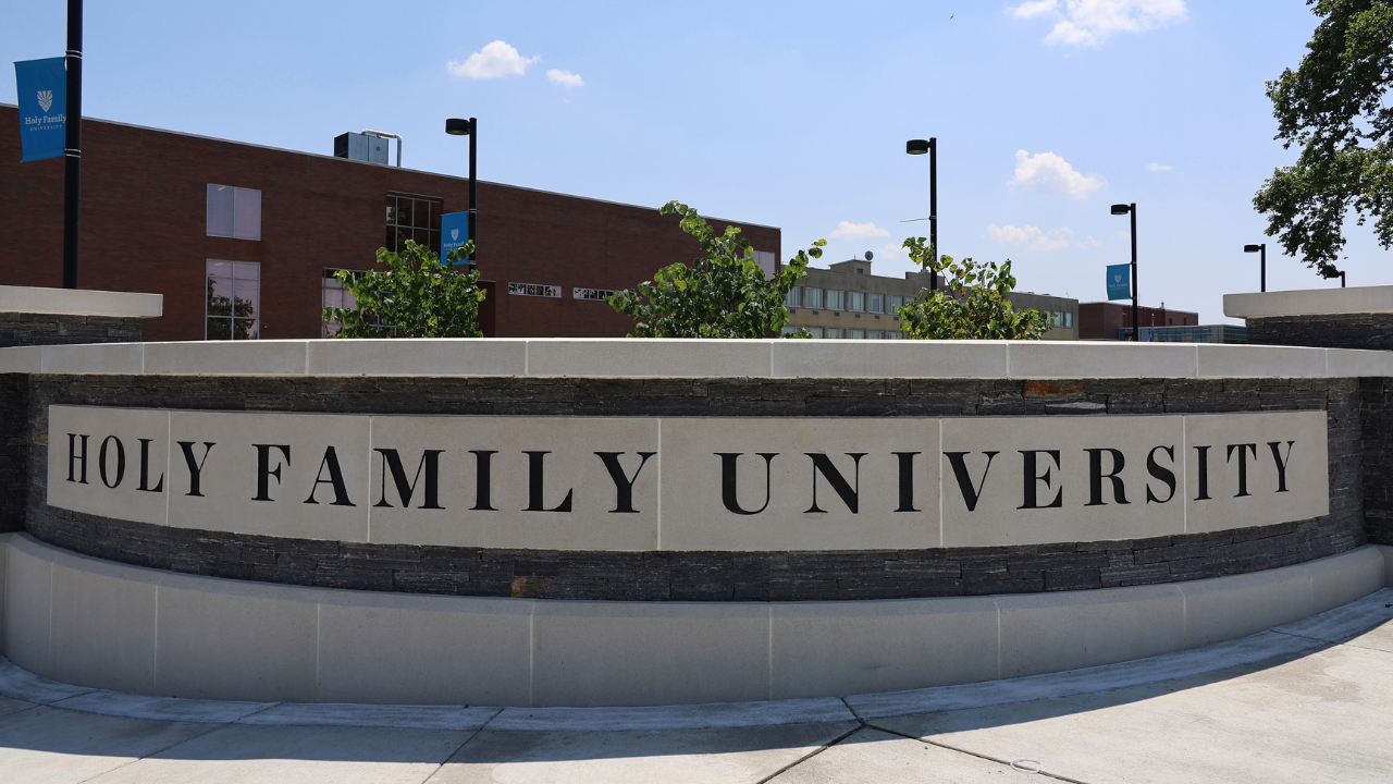 A wall by the entrance to campus with "Holy Family University" engraved in it